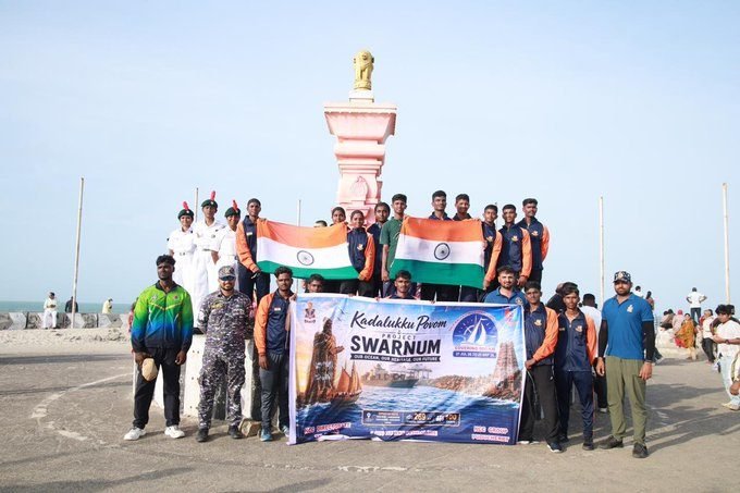 Cadets holding the national flag beside the memorial pillar at Kanniyakumari