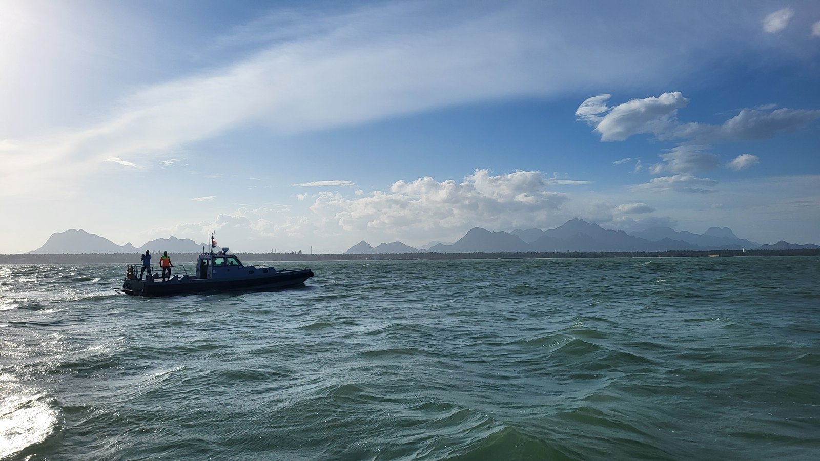 A patrol boat at sea off the Kanyakumari coast, Western Ghats visible on the horizon