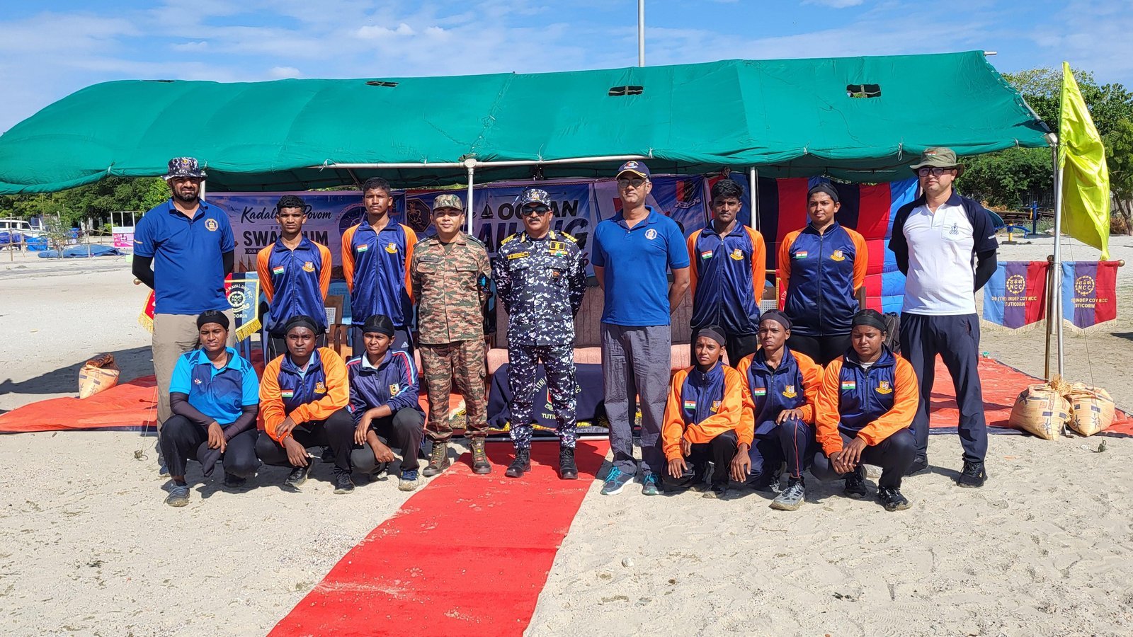 Second team photo at the beach camp tent with a smaller group of cadets and officers